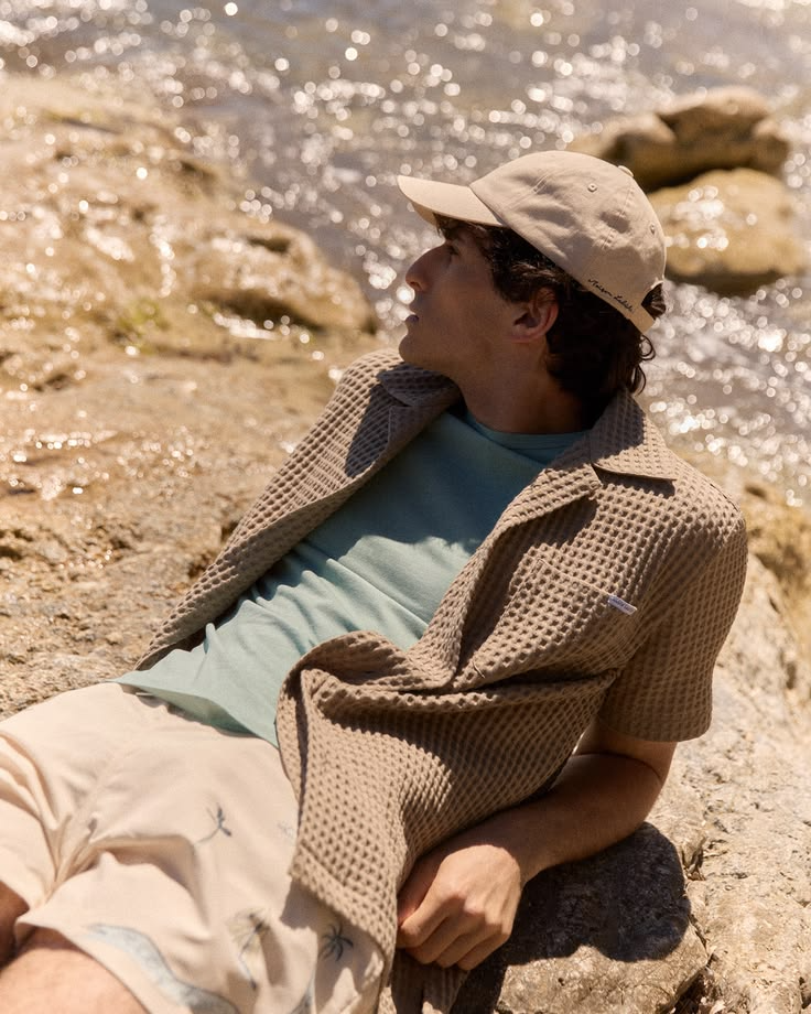 Ragazzo in look RITMO sulle rocce della riviera ligure con il mare sullo sfondo