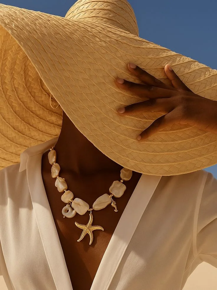 Collana con perle e stella marina, cappello di paglia